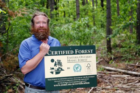 Quinte Conservation's Tim Trustham holds a new certification sign Thursday at Vanderwater Conservation Area near Tweed, ON